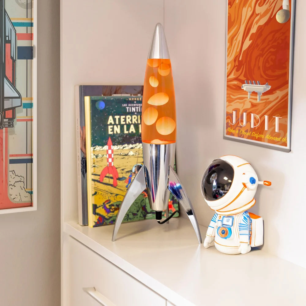 Fisura Raket Lavalamp met Oranje Lava - Chrome op een kastje naast ruimtelijke elementen
